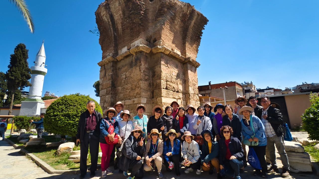 Tour group beside ancient ruins and a minaret